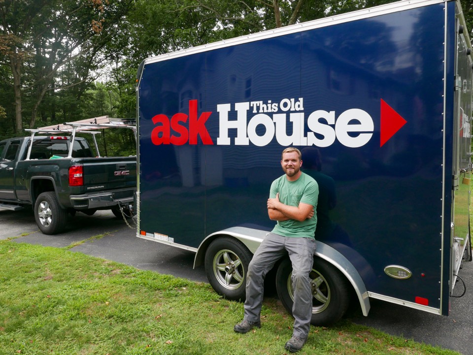 A crew member next to the Ask This Old House trailer